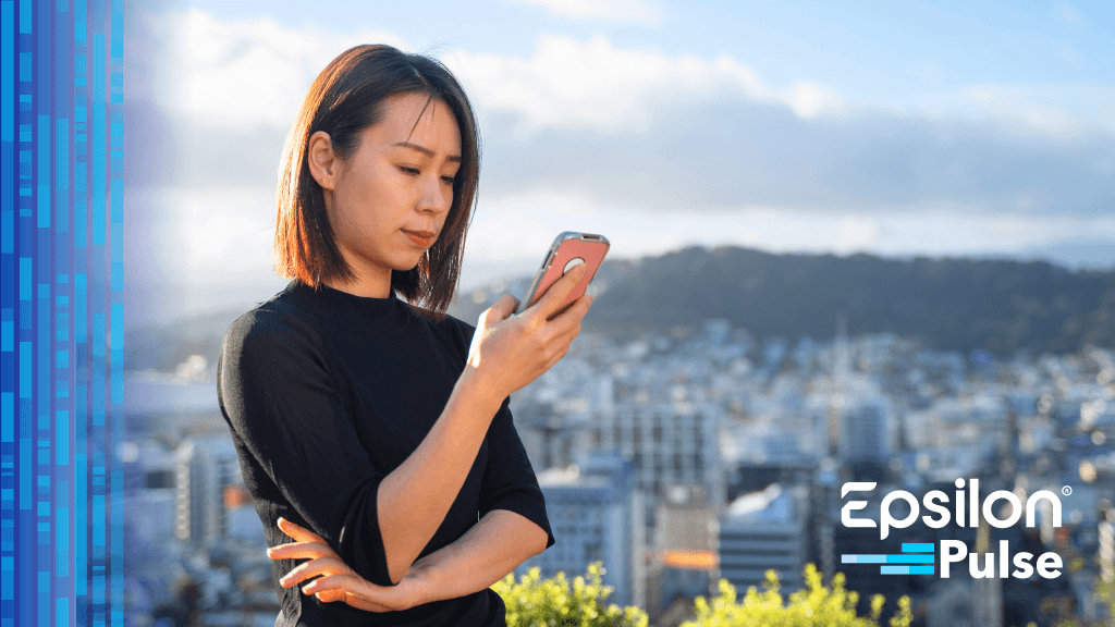 Woman looking at her phone over a cityscape background