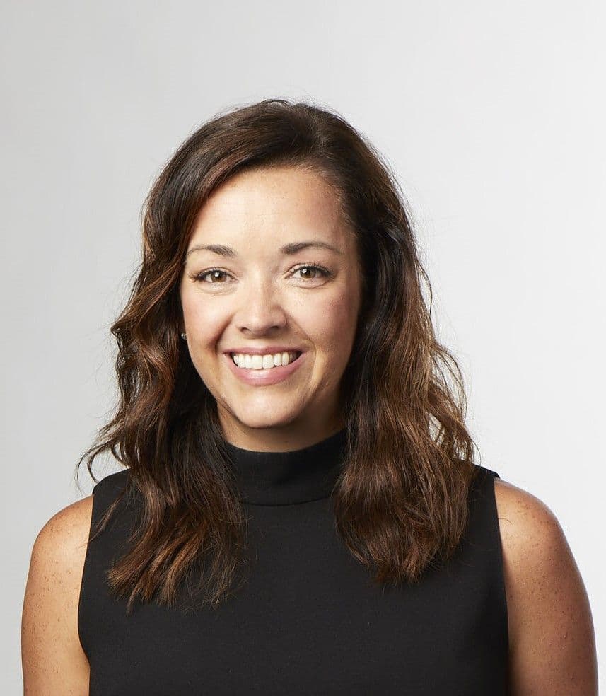 Headshot of a smiling woman with long brown hair.