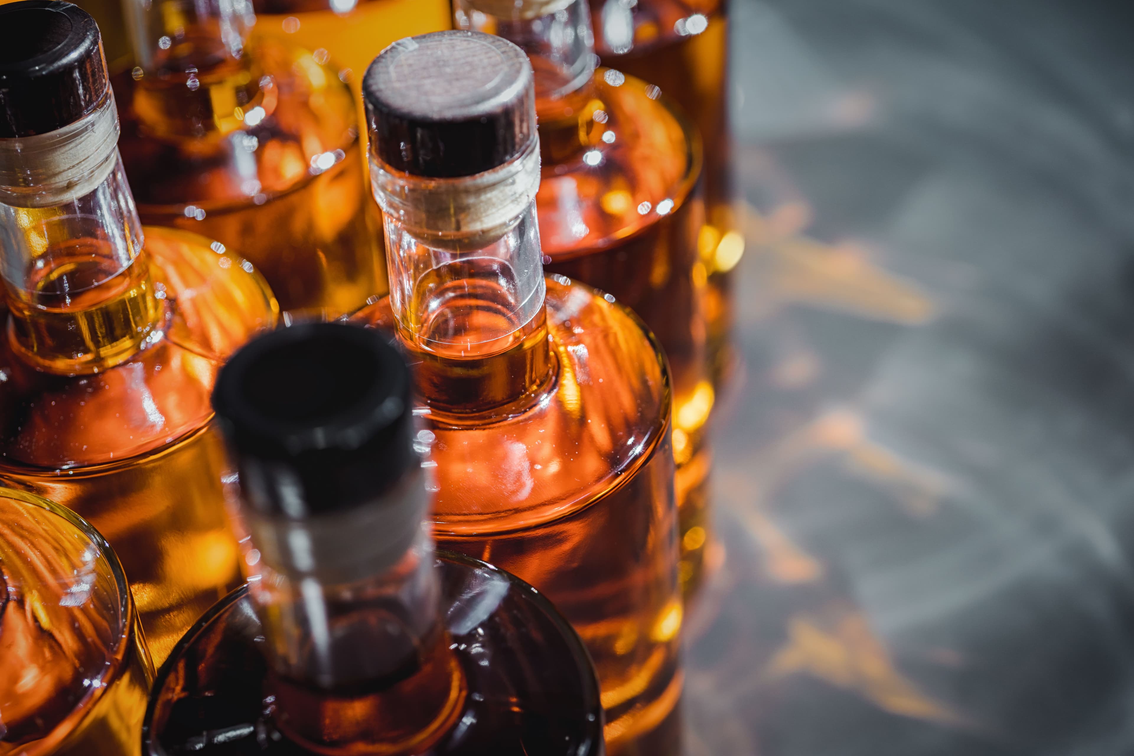 Multiple bottles of adult beverages with various corks and caps.
